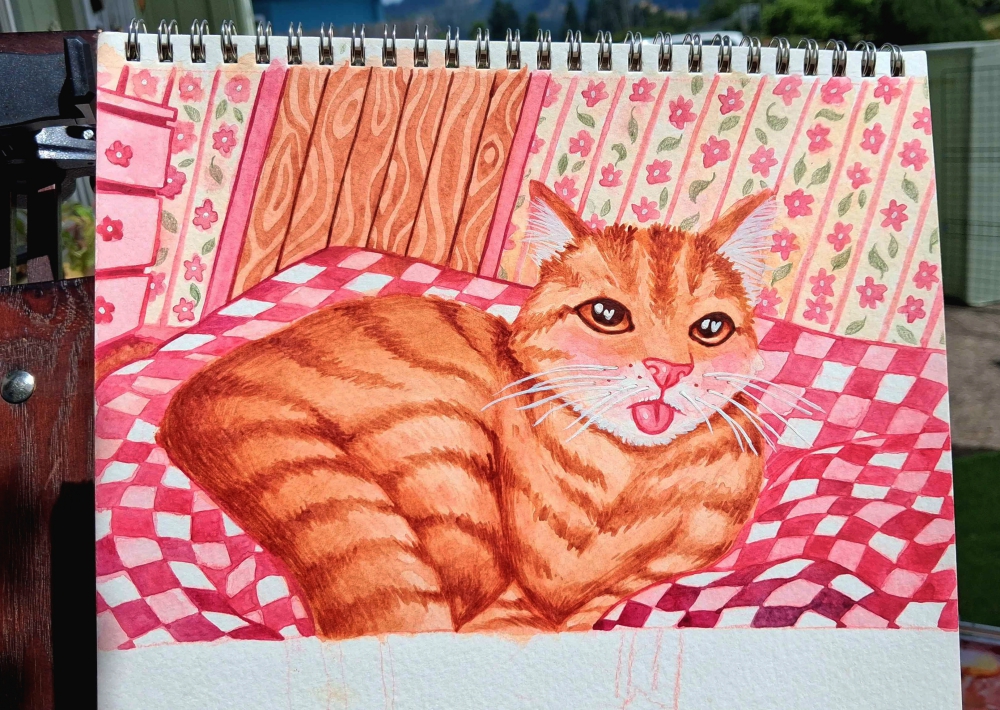 The finished watercolor painting of an orange tabby cat with a blep lying on a patterned pink and red quilt. The background features decorative wallpaper and a wooden panel, creating a cozy, detailed scene.